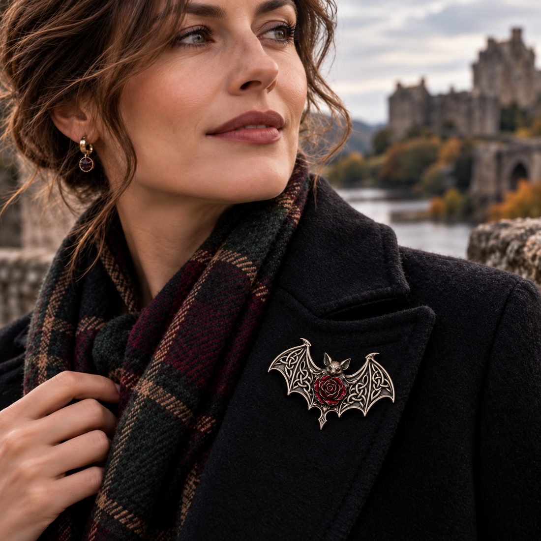 Bat and red rose brooch styled on a black coat with a plaid scarf