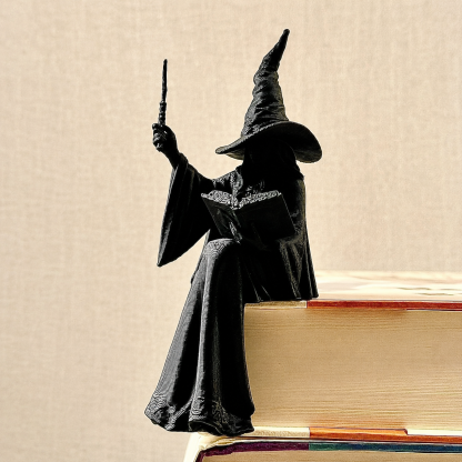 Black witch ornament sitting on the edge of books